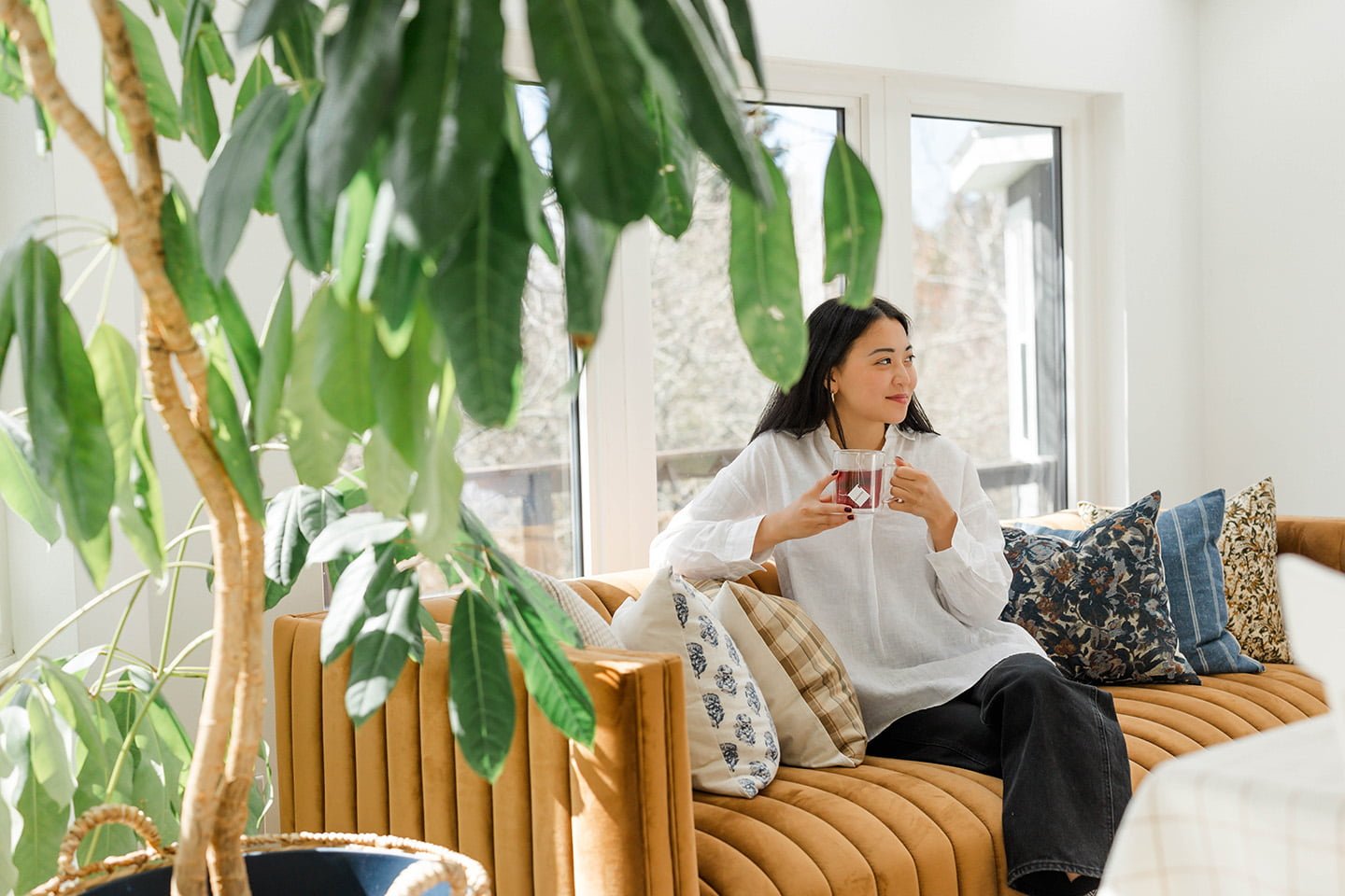 Woman on Sofa Drinking AASANA Tea